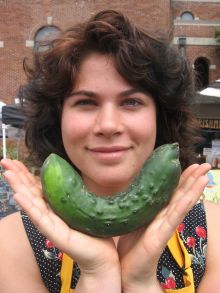 market volunteer with a cucumber