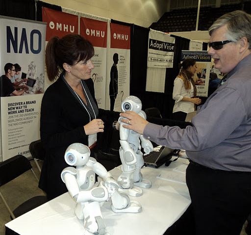 NOA robot display table with poeple admiring the product. 