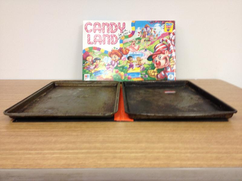 Photo of two cookie sheets and the board game Candyland. 