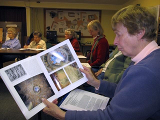 Renaissance Art class students examine a book.