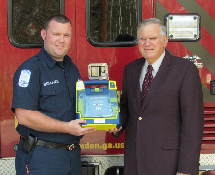 Stuart Sullivan and Chair David L. Rainer pose with an AED.
