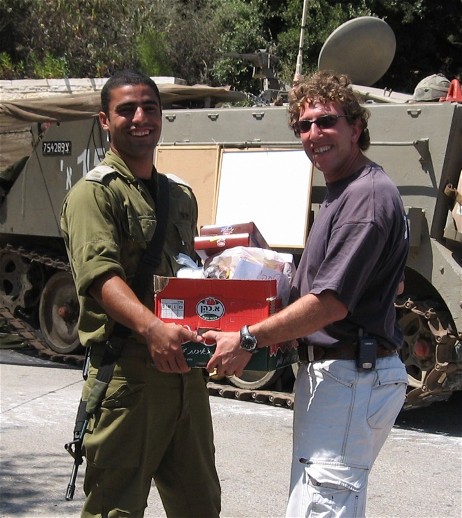 A solider shaking a man's hand and holding a goodie basket