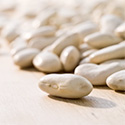Dry white beans on a table top.