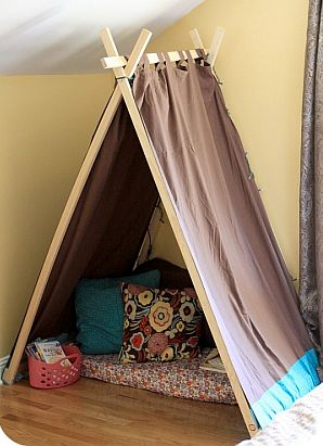 indoor tent made with boards and fabric, pillows inside