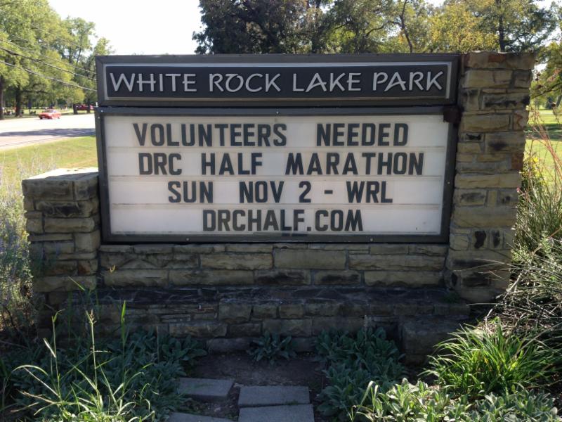White Rock Lake Park monument announcing Volunteers Needed DRC Half Marathon Sun Nov 2 - WRL drchalf.com