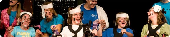 Summer campers, many in wheelchairs, smiling and dressed as dalmations for a play. 