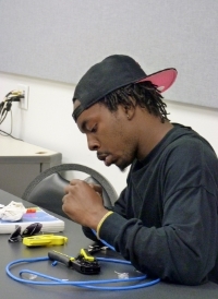 Morio Cathey attaches a connector to the wires he has stripped.