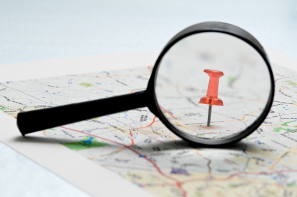 Map with magnifying glass and push pin
