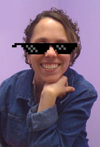 Julia Thomas with cartoon sunglasses over her face. She is smiling and has her hand under her chin.