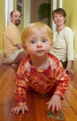 baby in pajamas crawling hallway
