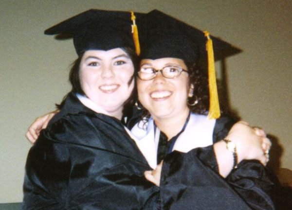 Julia poses with a friend in her graduation outfit