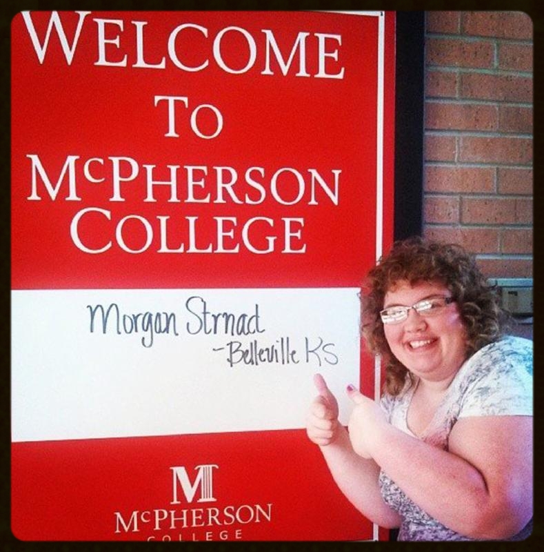 Morgan Strnad gives a thumbs up to a McPherson College sign