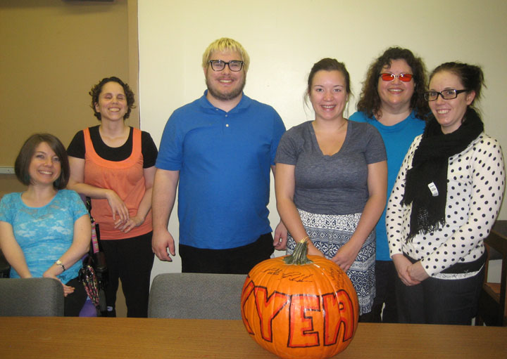 KYEA staff pose for a group photo with a pumpkin in front of them that says KYEA